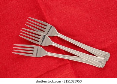 Three Metal Forks On A Red Linen Napkin, Macro, Top View.