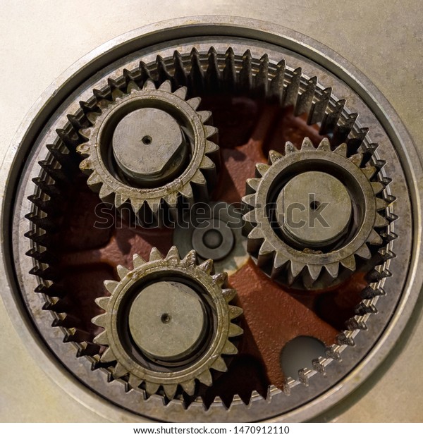 Three metal gears in a large gear mechanism .\
Industrial equipment. Close\
up.