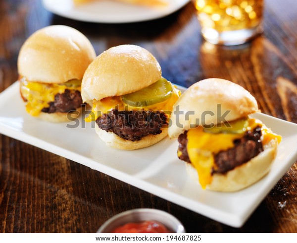 three mini burger sliders in\
a row