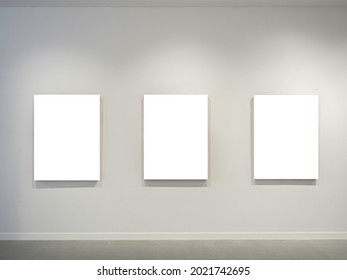 Three Mockup White Blank Museum Art Frames On White Clean Wall Background With Lighting.