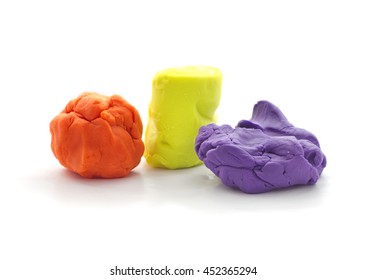 Three Modeling Clay Balls Of Different Colors Isolated On A White Background