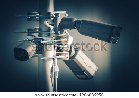 Three Modern Security Megapixel CCTV Cameras Installed on Aluminium Outdoor Pole. Closed Caption Television Technologies. 