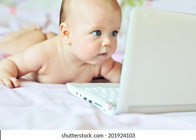 three months baby with laptop at home