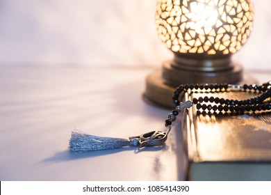 Three months.Islamic Holy Book Quran with rosary beads under soft light on white background. Ramadan concept .