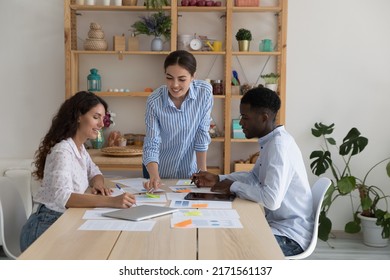 Three multi racial teammates work together on sales stats analysis, make notes take part in group meeting led buy executive manager in office. Teamwork, briefing event of diverse company staff concept