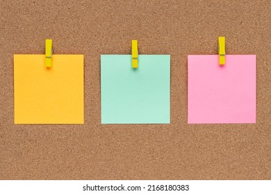 Three multicolor sticky notes on cork bulletin board, reminder important information. Blank square paper, modern template, frame. Planning concept.