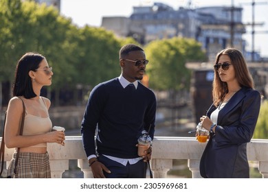Three multiracial co workers are talking to each other while taking a break from work