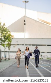 Three Multiracial And Young Business Co Workers Are Walking Together Towards The Company