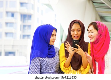 Three Muslim woman are having a chat in the city