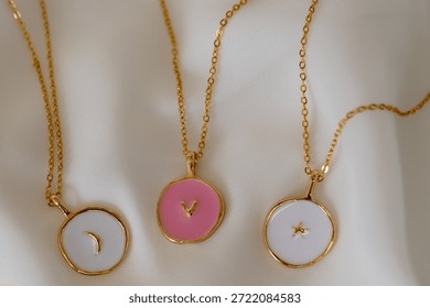 Three necklaces with different colored circles on them. The necklaces are on a white background.