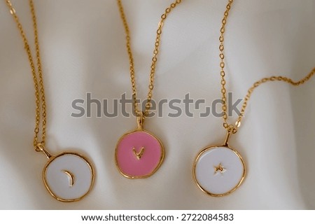 Three necklaces with different colored circles on them. The necklaces are on a white background.