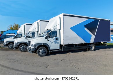 Three new white trucks ready for departure are parked. Delivery or shipment of goods in a conceptual manner.