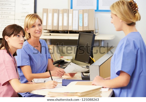 Three Nurses Working At\
Nurses Station