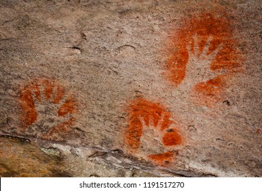 Three ochre hands, Red/Orange hand prints on a rock, Aboriginal art in Queensland, Australia. - Powered by Shutterstock