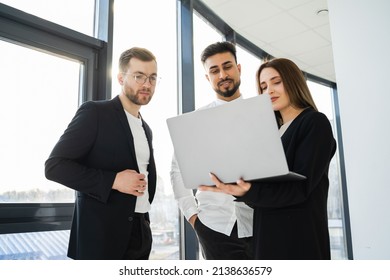 Three Office Workers Watching A Project On A Laptop