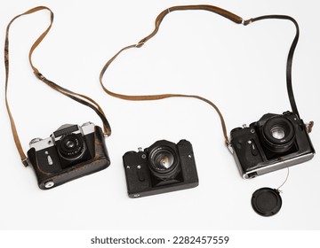 three Old, aged film cameras in black leather cases isolated on white background. 3 Vintage soviet union photo cameras. made in USSR. 