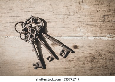 three old keys on table wooden background