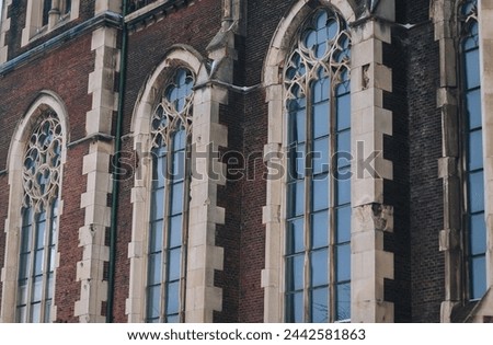 Three old pointed openwork gothic windows with stained glass on facade of the building. Baroque and Gothic architecture. Church of St. Olga and Elizabeth. Lviv, Ukraine. Stock photo © 