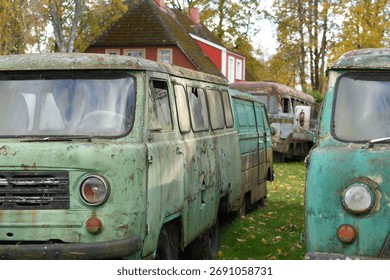 Three Old Rusty Abandoned Soviet Vans Parked in a Grassy Field in Autumn