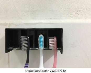Three old toothbrushes arranged in a row.