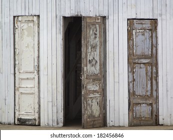 Three Old Wooden Doors, One Of Them Is Open