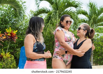 Three Older Women Greeting Each Other During A Pool Party.