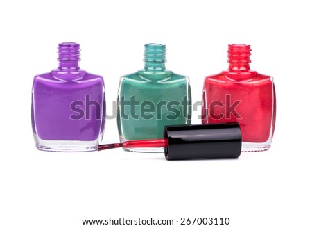 Three open bottles with colored nail polish and brush on a white background