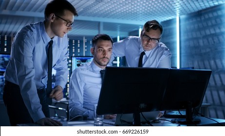 Three Operations Engineers Solving Problem in a Monitoring Room. In System Control Room Multitple Displays Show Various Data. - Shutterstock ID 669226159