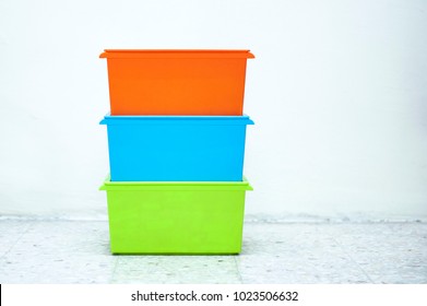 Three Orange, Blue And Green Storage Boxes Stacked With White Background