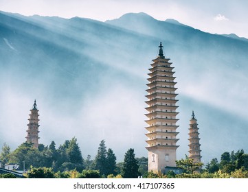 The Three Pagodas of Chongsheng Temple near Dali Old Town, Yunnan province, China. Scenic mountains are visible in background. Ancient pagodas are a popular tourist destination of Asia. Toned image.