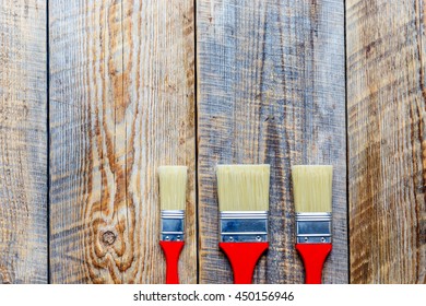 three paint brush on wooden floor top view - Shutterstock ID 450156946