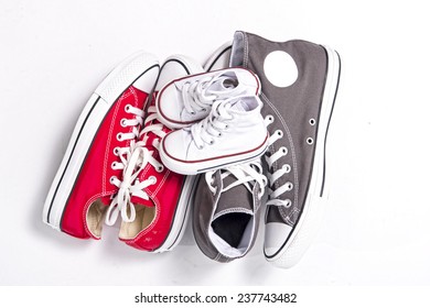 three pair of shoes in father big, mother medium and son or daughter small kid size representing family, growth, education and togetherness concept 