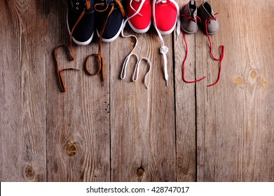 three pair of shoes in father big, mother medium and son or daughter small kid size on wooden desk , representing family, growth, education and togetherness concept 