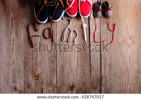 three pair of shoes in father big, mother medium and son or daughter small kid size on wooden desk , representing family, growth, education and togetherness concept 