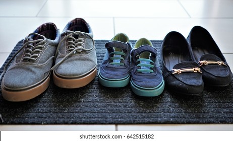 Three Pair Of Shoes Lined Up Next To Each Other. Man's Shoes, Woman's Shoes And Kid's Shoes In The Middle. Concept Of Small Family, Bonding, And Togetherness. Abstract Image Of Family.