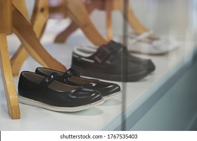 Three Pairs Of Children's School Shoes In A Transparent Display Case Of A Clothing Store. Preparing For The New School Year.