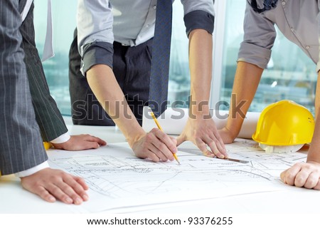 Three pairs of hands sketching a housing project