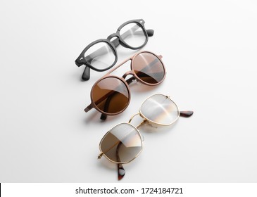 Three Pairs Of Men Eyeglasses And Sunglasses, With Reflection And Shadow. White Background Isolated. Summer Eyewear Fashion Concept. Isometric View.