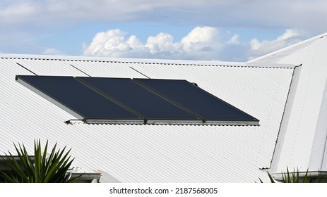 Three Panel Solar Hot Water System On A White Metal Roof