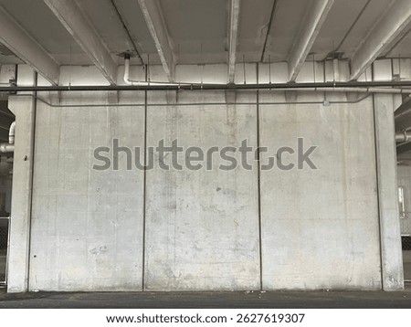Three panels of concrete wall in a construction area at a public transit bus stop under a freeway bridge. Located in Alexandria, Virginia, United States of America, North America.