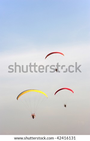 Three Paramotors on Blue Sky
