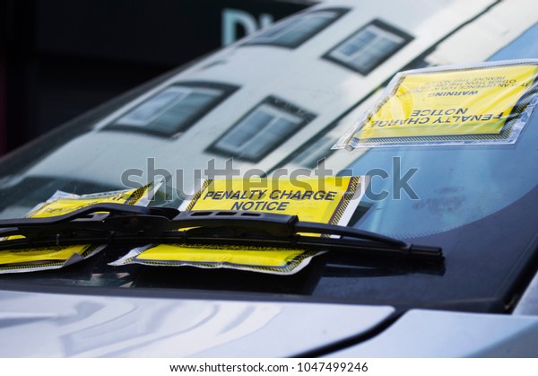 Three Parking Tickets\
on Car Windscreen