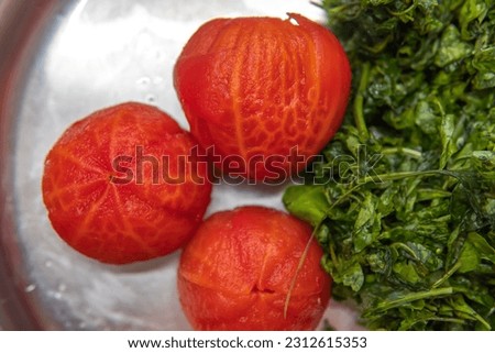 Three peeled tomatoes kept in a plate with some green leaf that adds a touch of healthy lifestyle and natural elegance
