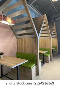 The three pendopo has a conical shape made of wood and has green tables and sofa chairs