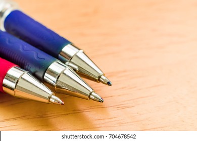 Three pens, Red and blue pen, macro focus on tip end cap on wooden desk table , Concept for Education, Business or Creative thinking.