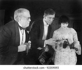 Three people checking out a manual drill