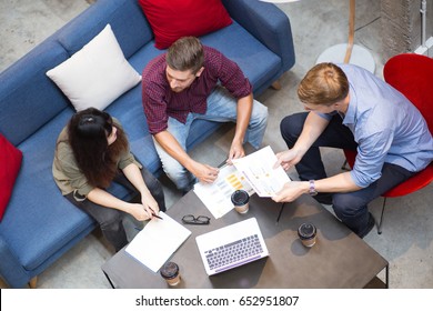 Three People Discussing Business Strategy In Cafe