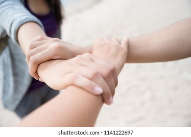 Three People Join Hands Together On White Sand Beach Background. Friendship Day, Collaboration Of Business And Education Teamwork Concept.