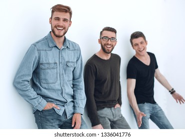 three people leaning against the wall, smiling - Shutterstock ID 1336041776