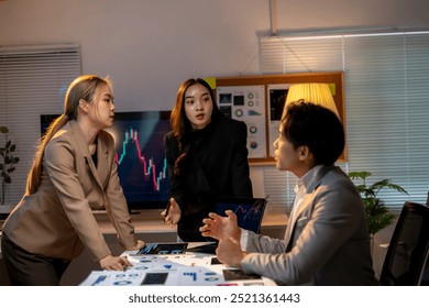 Three people are sitting at a table in a room, with one of them looking at a computer screen. Scene is tense, as the people seem to be discussing something important